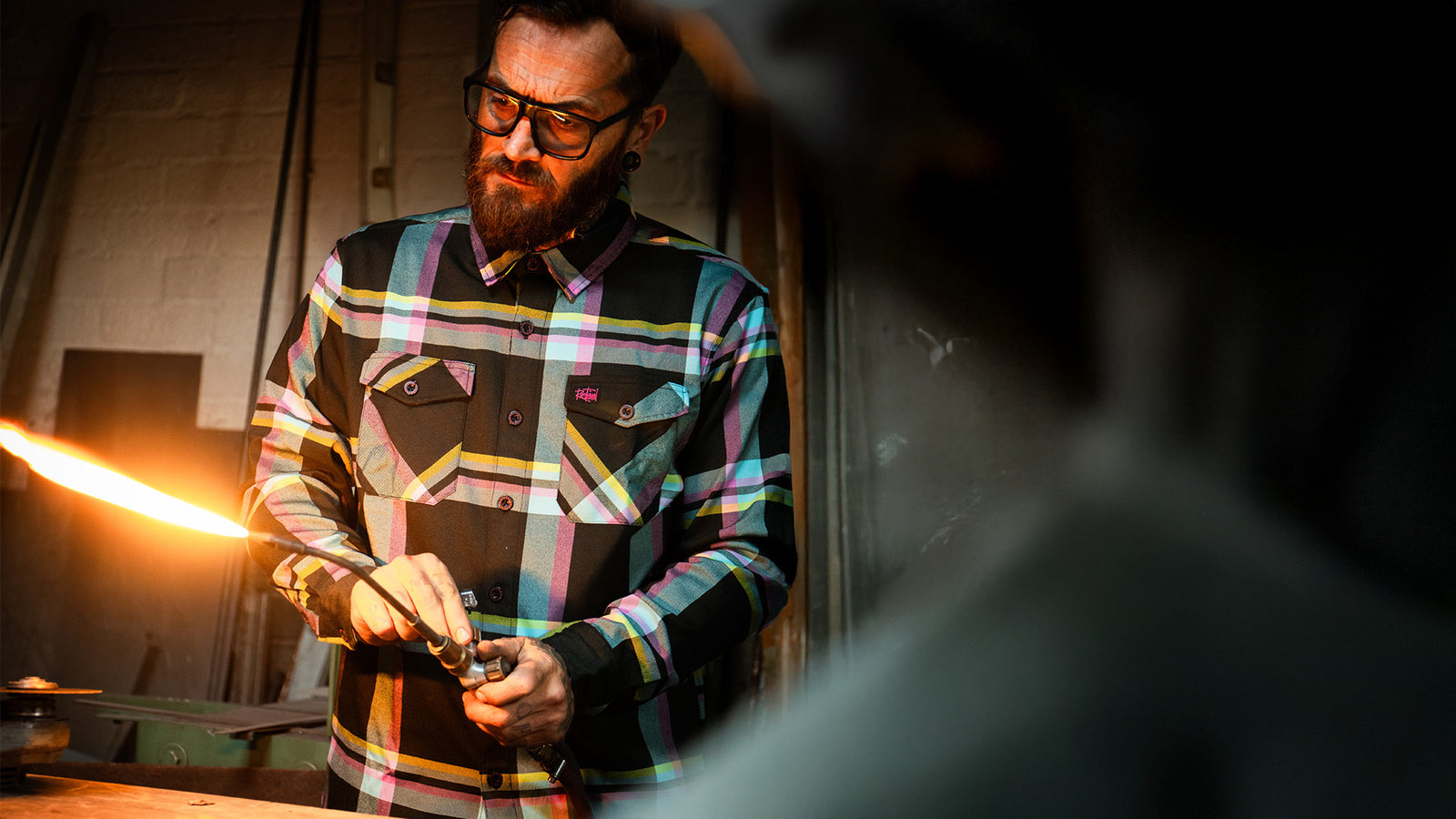 pinstriper blue pink and yellow flannel worn by a guy with a torch working on his classic vehicle